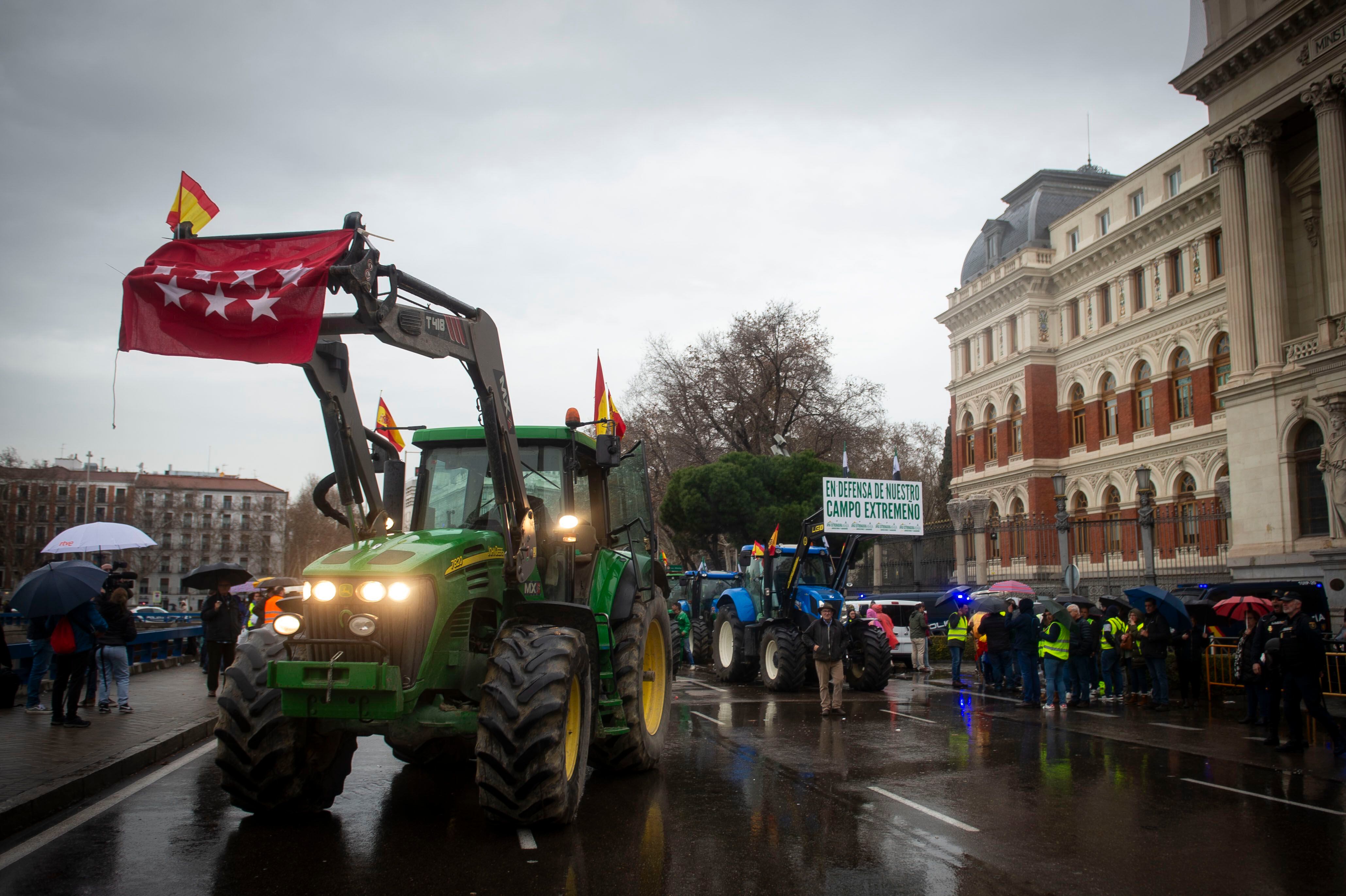 Agricultores aplauden la llegada de una veintena de tractores ante el Ministerio de Agricultura, este jueves en Madrid. 