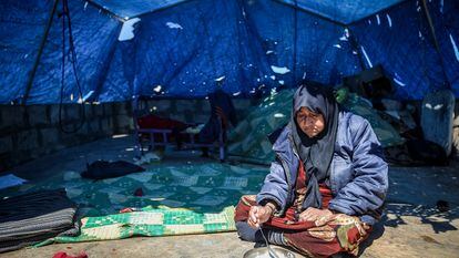 Una mujer come en la entrada de la tienda de campaña en la que vive en Idlib (Siria), en vísperas del mes sagrado del Ramadán.