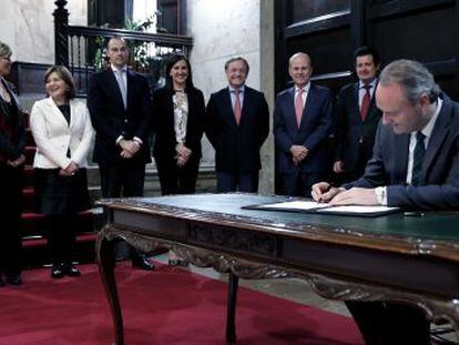 El presidente de la Generalitat firma el decreto de disoluci&oacute;n de las Cortes delante de su Gobierno.