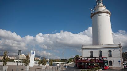 Un autobús turístico pasa frente a La Farola para que los visitantes puedan ver de cerca el histórico faro malagueño.