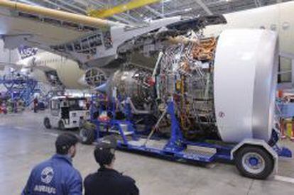 Dos trabajadores participan en el montaje de los dos motores Rolls-Royce Trent XWB del nuevo modelo de avi&oacute;n Airbus A350 XWB, en Colomiers, Francia.