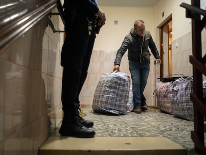 Rachid El Yagoubi saca, en presencia del un policía, sus pertenencias del piso del que ha sido desahuciado este viernes