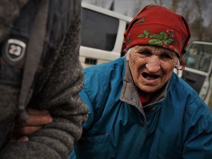 Melania Yakovchuk, de 80 años, del brazo de su hijo Fedor, de 60, durante su evacuación de Dvorichna, en el frente de Járkov, el martes.