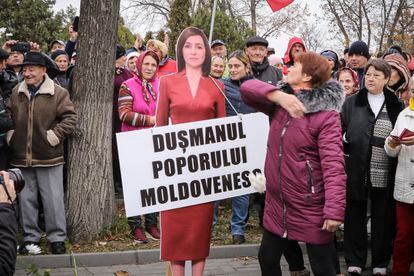 Una mujer golpea una figura de cartón de la presidenta de Moldavia, Maia Sandu, durante una protesta iniciada por el populista Partido Sor, en Chisinau el día 13.
