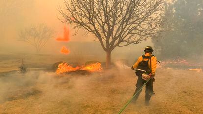 Un miembro del Departamento de Bomberos de Flower Mound, en Texas (EE UU), ayudando a contener un incendio forestal el pasado 27 de febrero.