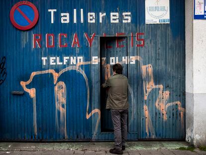 Un trabajador autónomo cierra la puerta de su taller mecánico, este viernes en Santiago de Compostela.