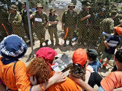Agentes de seguridad israelíes vigilan a manifestantes contrarios a la retirada de Gaza, ayer en Kafar Maimon.