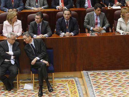 Joaquín Leguina y Alberto Ruiz-Gallardón (en primera fila) siguen el pleno extraordinario ante las filas del Gobierno regional.