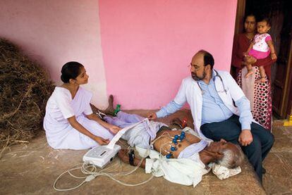 Un médico explora a un paciente con un dispositivo portátil, capaz de atender a los enfermos de las zonas rurales indias.
