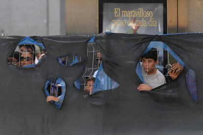Aficionados del Real Madrid se asoman por las vallas de las obras de la Puerta del Sol.