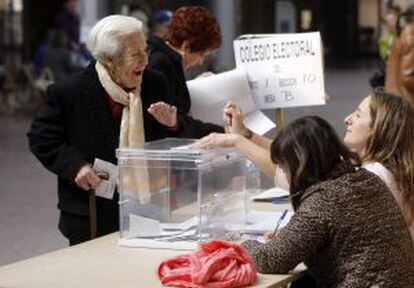 Una mujer vota en un colegio electoral en Gijón.