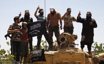 Combatientes islamistas del grupo Al Nusra gesticulan subidos a un tanque en la provincia siria de Idlib. / Hamid khatib (Reuters)