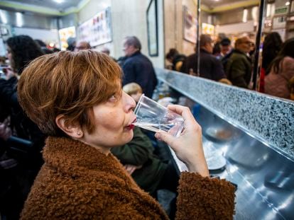Una mujer bebe un vaso de agua en lun bar cerca de la Plaza Mayor, en Madrid.