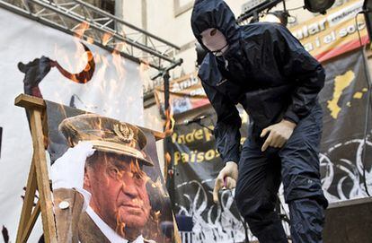 Un encapuchado quema una foto del Rey al final de la marcha independentista de Barcelona con motivo de la Diada.