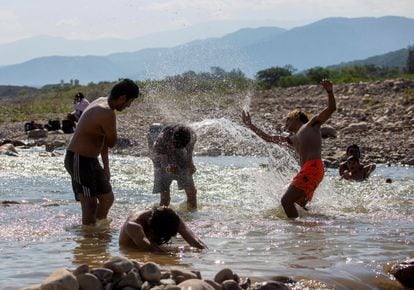 Un grupo de jóvenes juega con el agua en un río en Salta, Argentina. 