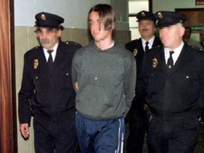 El joven, custodiado por agentes de la Policía tras ser detenido en Murcia en 2000.