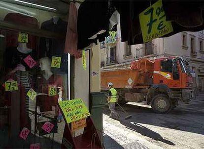 Un camión pasa delante de una tienda de ropa delante en la calle de Sant Medir.