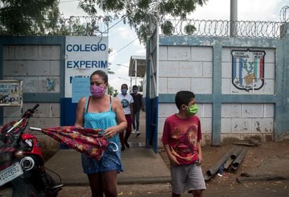 Una mujer junto a su hijo con mascarilla salen de una escuela pública en mayo de 2020, en Managua (Nicaragua). La Unidad Sindical Magisterial de Nicaragua denunció que los maestros nicaragüenses con síntomas de covid-19 no tenían acceso a las pruebas PCR, mientras las clases seguían sin ser suspendidas.  