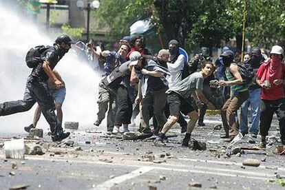 Un grupo de manifestantes se enfrenta a la policía tras la manifestación contra la cumbre del APEC en Santiago.
