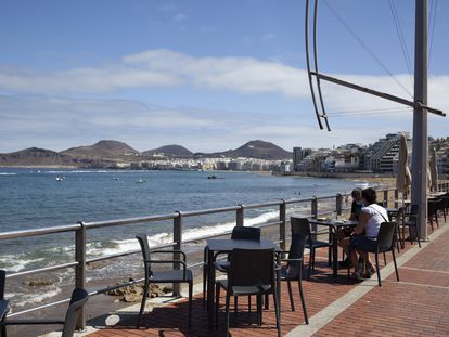 Dos personas sentadas en una terraza en la playa de Las Canteras, en Las Palmas de Gran Canaria.
