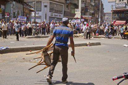 Un opositor del presidente egipcio Mohamed Morsi con un cuhcillo en las manos se enfrenta a los partidario del presidente en el centro de Damietta (Egipto), 3 de julio de 2013.