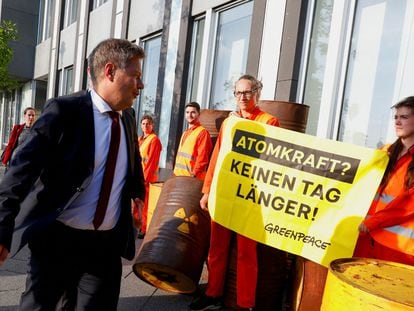 El ministro de Economía y Clima, Robert Habeck, pasa frente a un cartel que pide no prolongar "ni un día más" la energía nuclear en Alemania de camino a la rueda de prensa que ha ofrecido este lunes en Berlín.