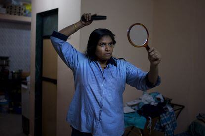 Rupa Modi, 38, peina su cabello antes de ir a trabajar. Rupa vive en Bombai con sus dos hijos. Su marido murió hace ocho años y a partir de aquel momento toda la familia de él está en contra de ella y de sus hijos. Ella trabaja de noche como taxista porque durante el día trabaja como costurera para poder pagar el alquiler de la casa y las educación de sus hijos.