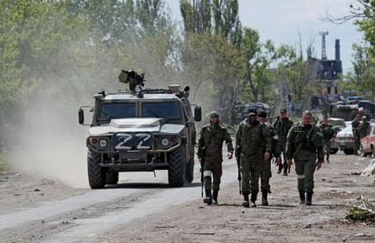 Miembros del servicio de las tropas prorrusas caminan por una calle en la ciudad portuaria sureña de Mariupol.