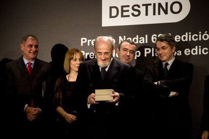 &Aacute;lvaro Pombo observa extasiado el premio Nadal ante la curiosa mirada de los miembros del jurado.