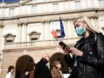 Una mujer joven lleva una mascarilla en Milán en prevención del coronavirus. En vídeo, Sanidad recomienda no acudir al hospital si no se presentan síntomas aunque se venga de una zona de riesgo.