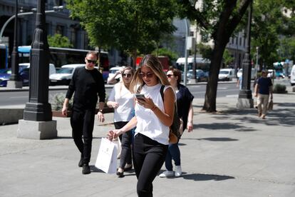 Usuaria de telefonía móvil en una calle de Madrid.