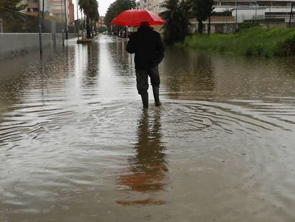 Un hombre camina en una calle anegada hoy en Dénia (Alicante).