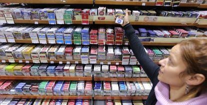 Una dependienta de un estanco muestra una cajetilla de tabaco, en Madrid.