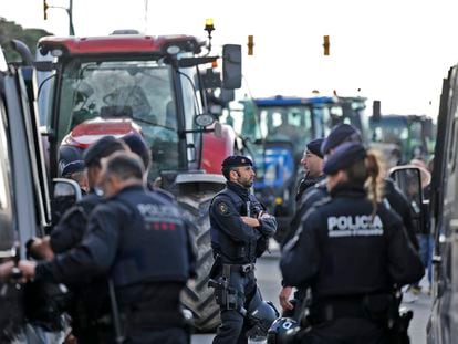 Los Mossos d'Esquadra junto a los tractores que bloquean la entrada a Mercabarna, este martes.