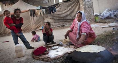 Una mujer cocina pan cerca de la ciudad de Alepo.