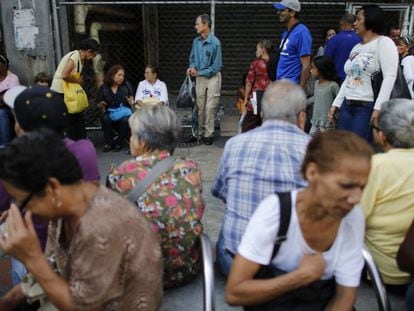 Venezolanos esperan en la entrada de un supermercado de Caracas, Venezuela, el 23 de agosto.