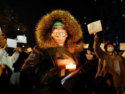 Una persona sujeta una vela durante la protesta del domingo en Pekín.