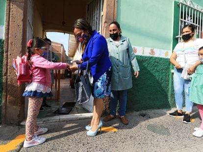 Una maestra toma la temperatura a una estudiante, durante el regreso a clases en León, Guanajuato, el pasado 11 de mayo.