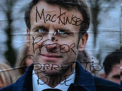 Un cartel electoral de Emmanuel Macron sobreescrito con el mensaje "Mac Kinsey, Pfizer, corrupción total", este domingo en París.