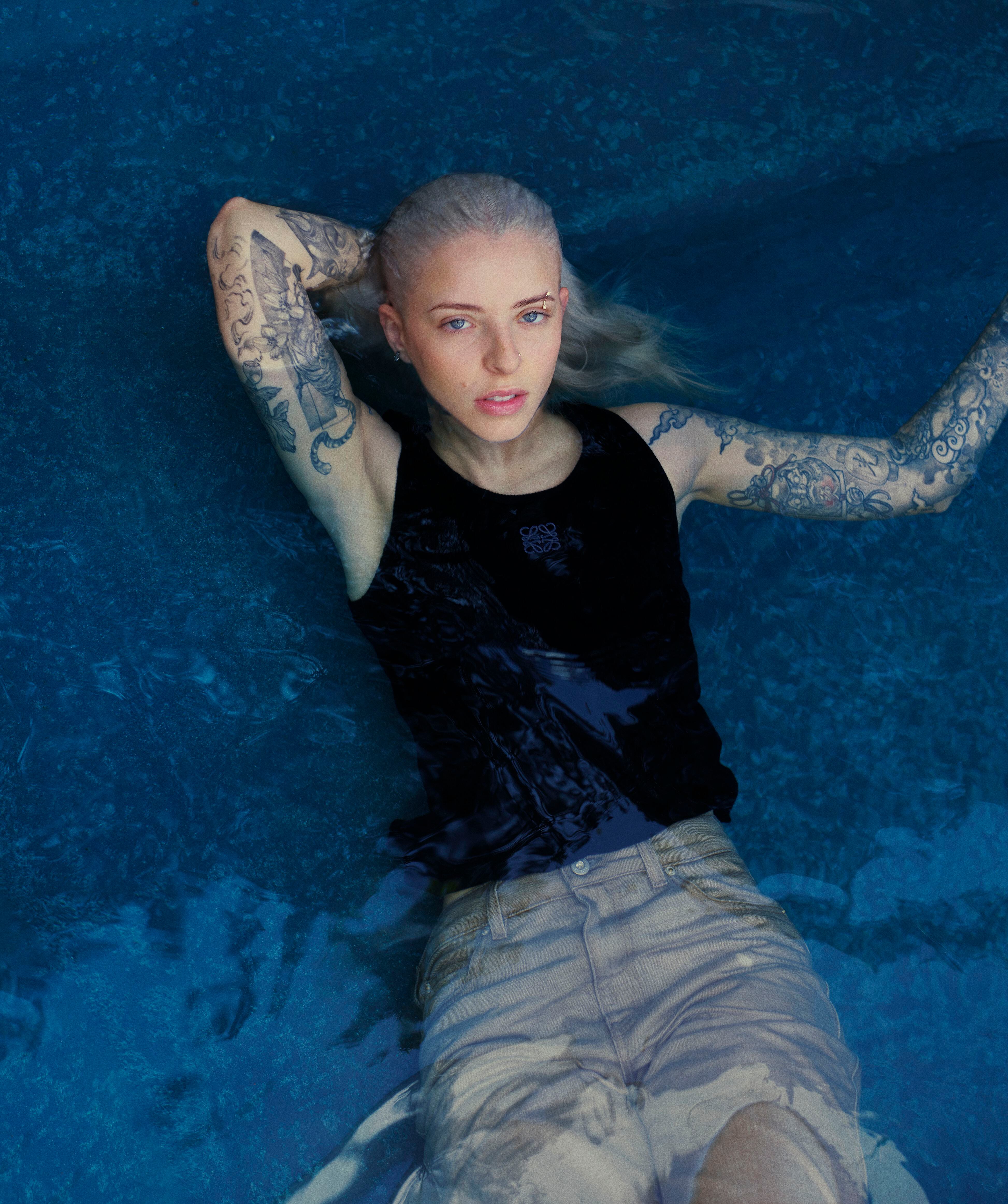 La artista con jeans y camiseta tank top de canalé de LOEWE Paula’s Ibiza.