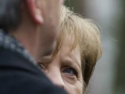 Angela Merkel mira a Juncker en una visita del presidente del Eurogrupo a Alemania.