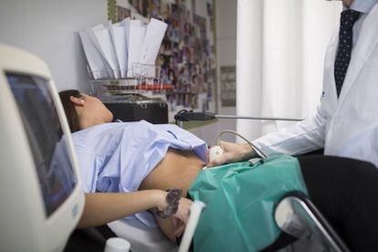 Un doctor fa una ecografia a una embarassada.