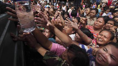 Víctimas de las inundaciones intentan coger botellas de agua potable en el distrito de Pluit en Jakarta (Indonesia), el 20 de enero de 2013.
