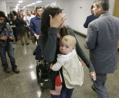 Una madre sale llorando de la sesión parlamentaria, con su hijo de nueve meses.