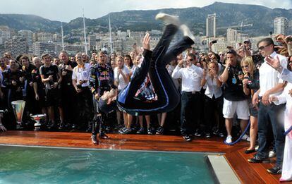 El piloto de Red Bull Mark Webber of Australia salta en una piscina para celebrar su victoria en el Gran Premio de Mónaco.