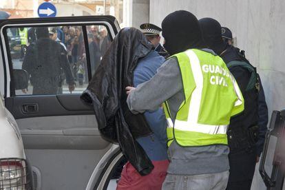 La Guardia Civil introduce en un coche al detenido en Santa Coloma de Farners (Girona).