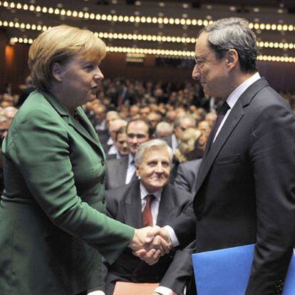 La canciller Merkel conversa con Mario Draghi ante la mirada de Jean Claude Trichet.