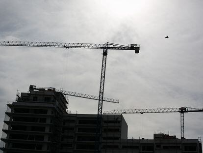 Grúas y edificio en construcción en contraluz de una promoción de viviendas en Barcelona