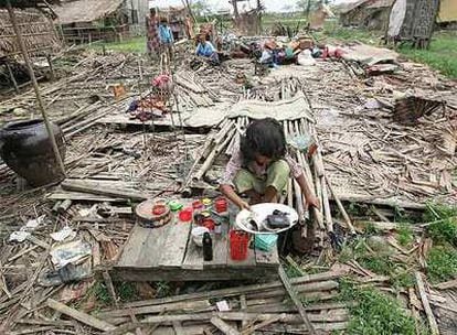 Una niña recupera objetos entre los escombros de su casa arrasada por el ciclón, en las afueras de Yangon.