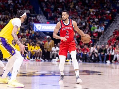 McCollum, de Nueva Orleans, maneja la pelota frente a Anthony Davis, de los Lakers.